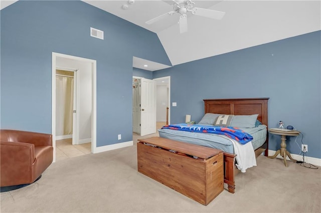 bedroom with ceiling fan, vaulted ceiling, light carpet, and a walk in closet