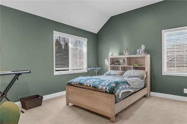 bedroom with multiple windows, lofted ceiling, and light carpet