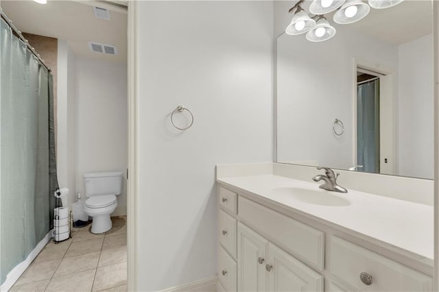 bathroom featuring vanity, tile patterned floors, and toilet