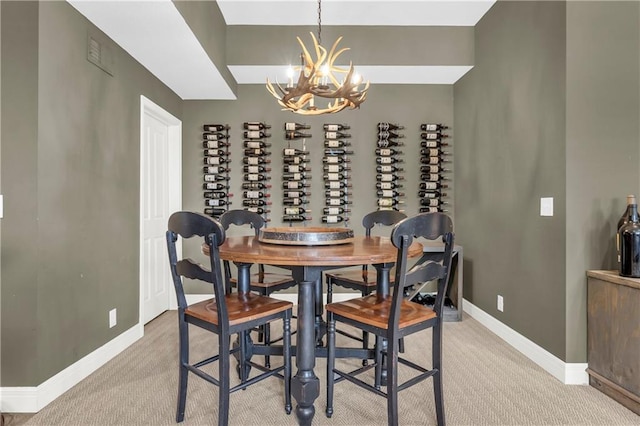 carpeted dining area with an inviting chandelier