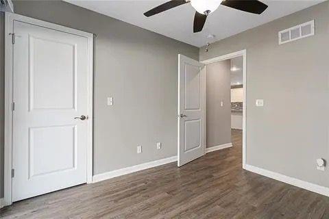 unfurnished bedroom featuring ceiling fan and dark wood-type flooring