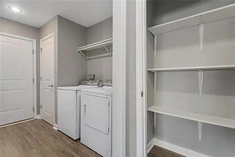 clothes washing area with dark hardwood / wood-style flooring and washer and clothes dryer