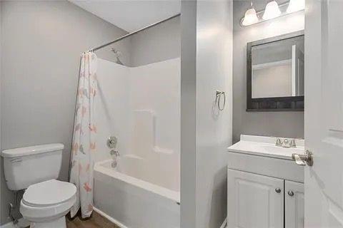 full bathroom with toilet, vanity, and shower / bathtub combination with curtain