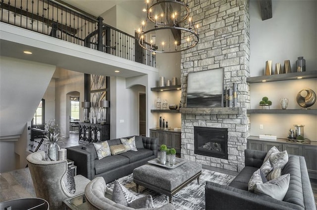 17028 Parkhill St, Overland Park, KS 66221 - living room with arched walkways, a chandelier, a fireplace, and a towering ceiling