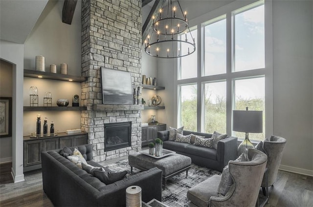 17028 Parkhill St, Overland Park, KS 66221 - living room featuring a towering ceiling, baseboards, dark wood-style floors, a stone fireplace, and a chandelier
