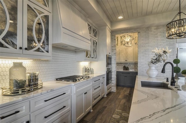 17028 Parkhill St, Overland Park, KS 66221 - kitchen featuring a sink, appliances with stainless steel finishes, dark wood-style flooring, decorative backsplash, and light stone counters