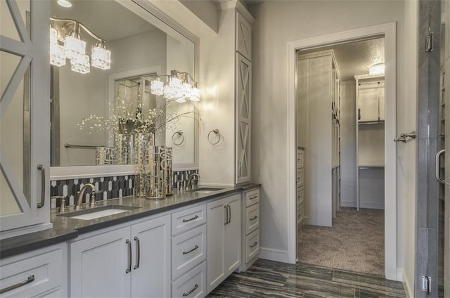 17028 Parkhill St, Overland Park, KS 66221 - bathroom featuring a chandelier, double vanity, and baseboards