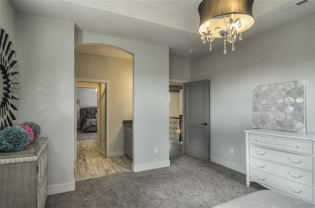 17028 Parkhill St, Overland Park, KS 66221 - bedroom featuring arched walkways, carpet floors, a chandelier, and baseboards