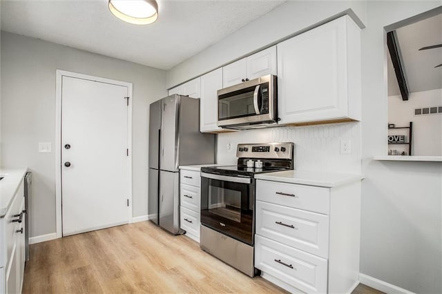 kitchen featuring stainless steel appliances, white cabinets, and light hardwood / wood-style floors