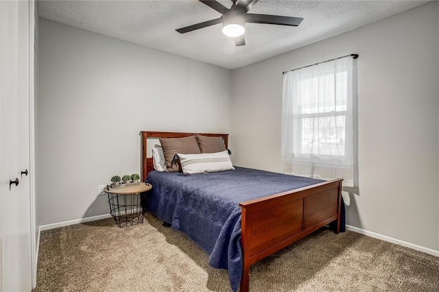 carpeted bedroom featuring ceiling fan and a textured ceiling