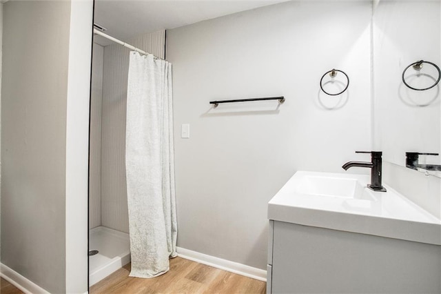 bathroom featuring vanity, wood-type flooring, and walk in shower