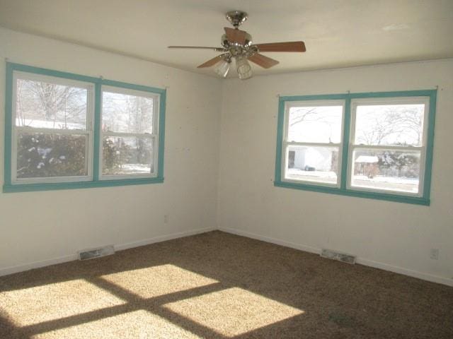 carpeted empty room with visible vents and baseboards