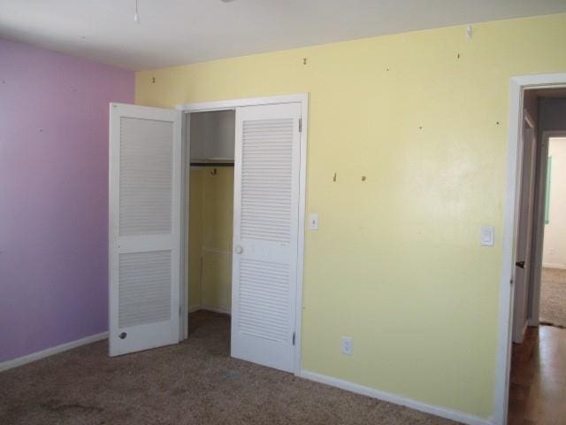 unfurnished bedroom featuring a closet, carpet flooring, and baseboards