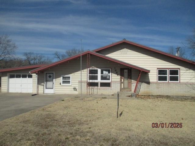 view of front of house with a garage, brick siding, and driveway