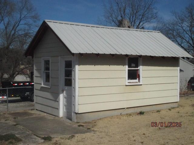 view of outdoor structure featuring fence and an outbuilding