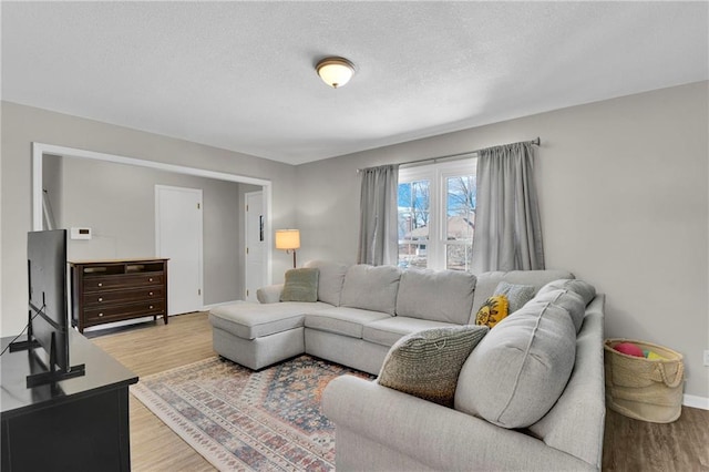 living room featuring a textured ceiling and light wood-type flooring