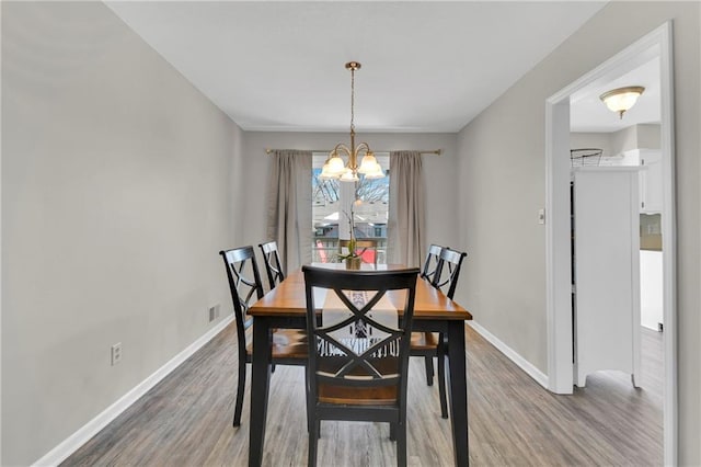 dining area with hardwood / wood-style flooring and a chandelier