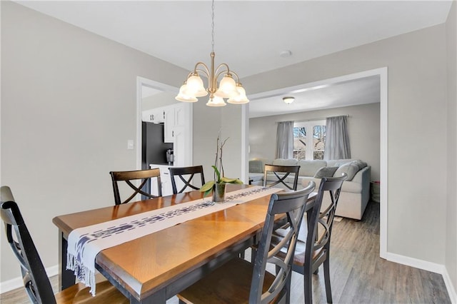 dining area with wood-type flooring and a chandelier