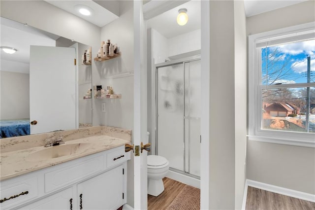 bathroom featuring vanity, toilet, hardwood / wood-style floors, and walk in shower