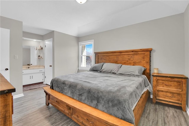 bedroom with hardwood / wood-style flooring and ensuite bathroom