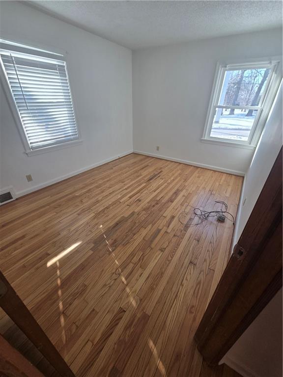 empty room with hardwood / wood-style flooring