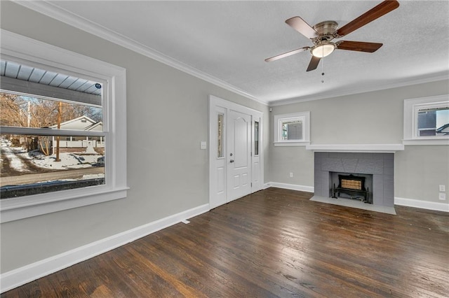 unfurnished living room with dark hardwood / wood-style flooring, ceiling fan, crown molding, and a tiled fireplace