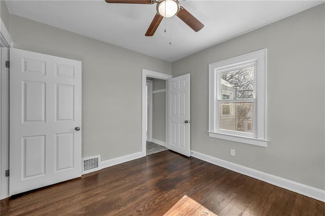 unfurnished bedroom featuring ceiling fan and dark hardwood / wood-style floors