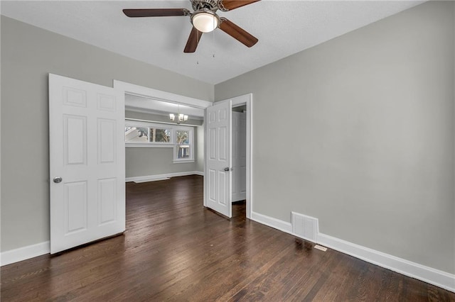 unfurnished bedroom with dark wood-type flooring and ceiling fan with notable chandelier