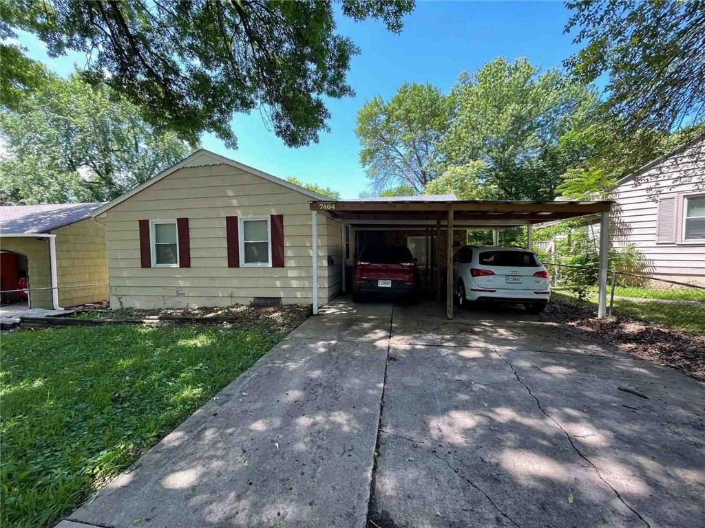 ranch-style home with a front lawn and a carport