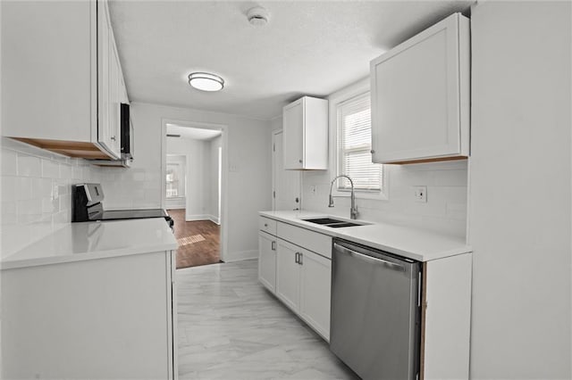 kitchen with sink, appliances with stainless steel finishes, a textured ceiling, white cabinets, and decorative backsplash