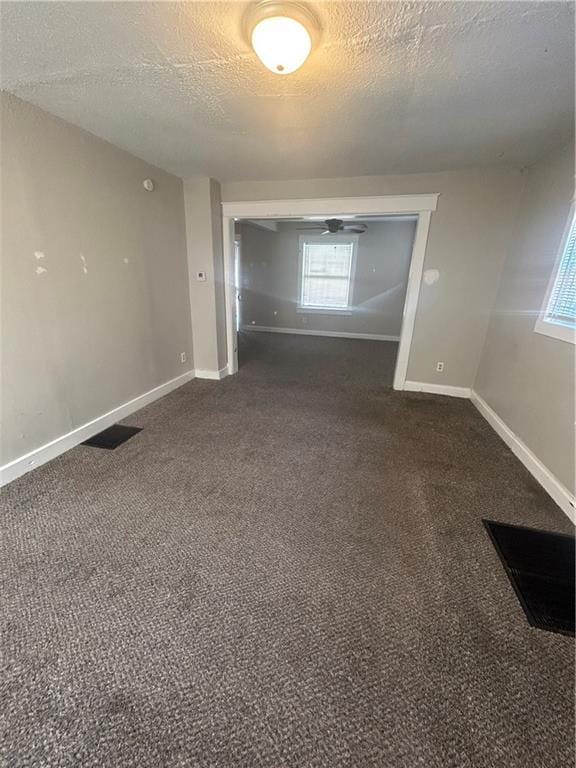 carpeted empty room with a textured ceiling