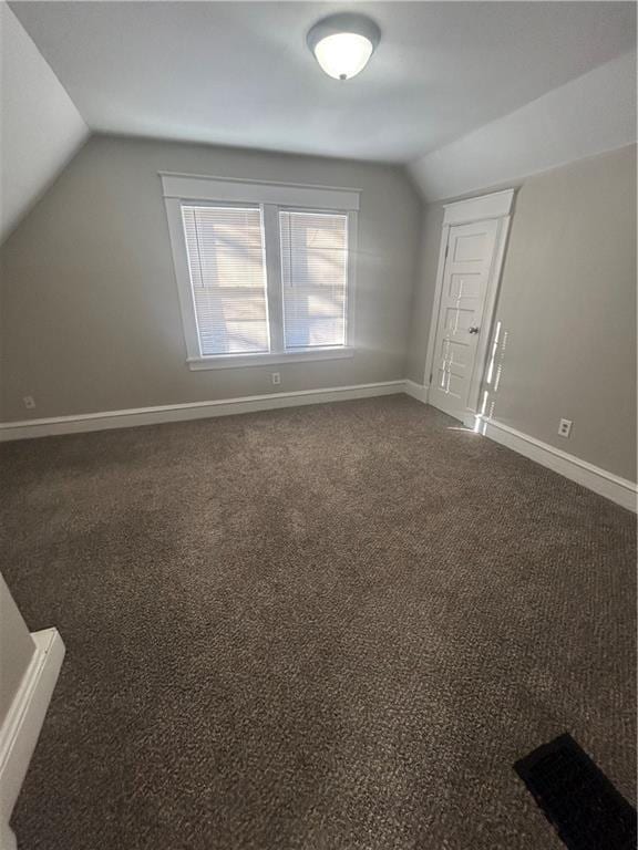 additional living space with lofted ceiling and dark carpet