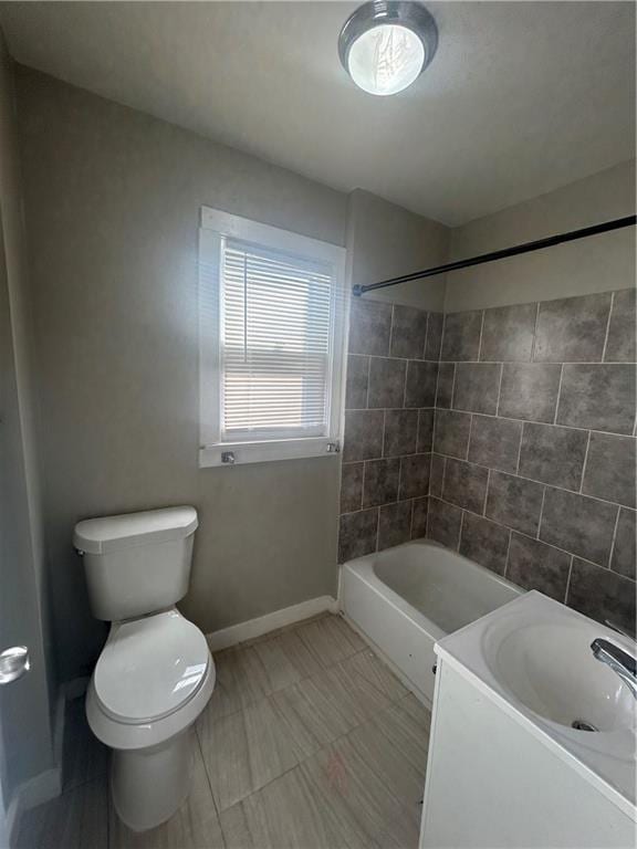 full bathroom with toilet, tiled shower / bath, and vanity