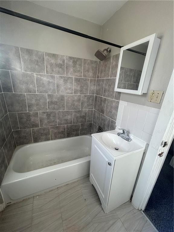 bathroom with tiled shower / bath combo and vanity