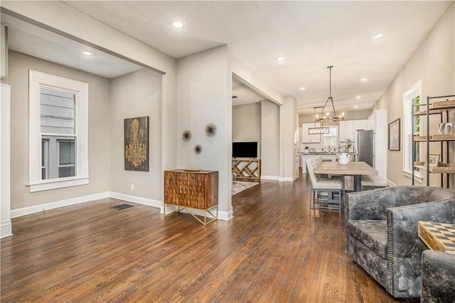 living room featuring a notable chandelier and dark hardwood / wood-style floors