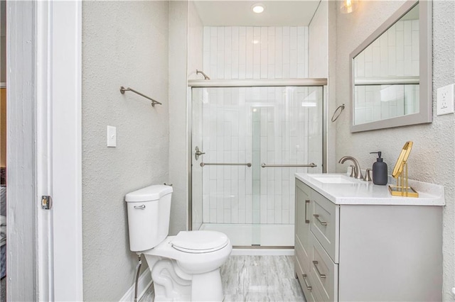 bathroom featuring toilet, vanity, and walk in shower