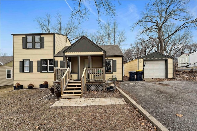 view of front of house featuring a garage, an outbuilding, and covered porch