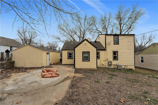 rear view of house with cooling unit and a storage unit