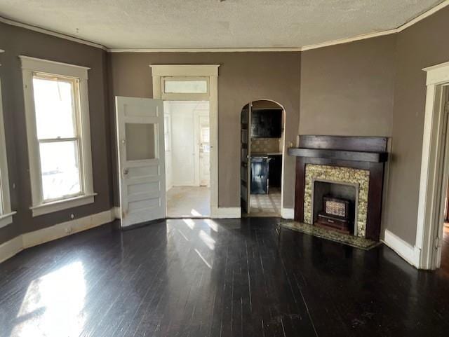 unfurnished living room featuring dark hardwood / wood-style flooring, a textured ceiling, and ornamental molding