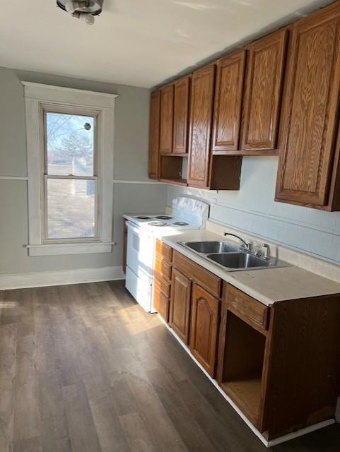 kitchen featuring white range with electric stovetop, sink, and dark wood-type flooring