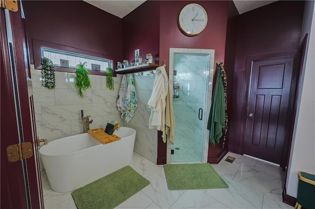 full bathroom featuring a soaking tub, marble finish floor, and a marble finish shower