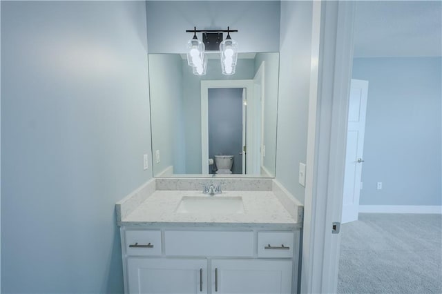 bathroom featuring baseboards, toilet, and vanity