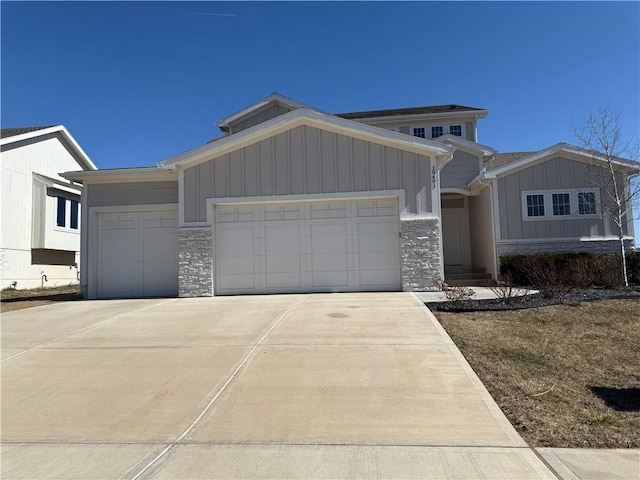 view of front of home featuring stone siding, board and batten siding, driveway, and a garage