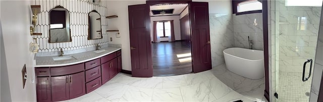 bathroom with a freestanding bath, marble finish floor, and vanity