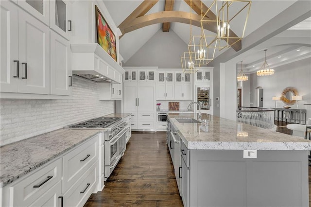 kitchen with double oven range, pendant lighting, white cabinets, and sink