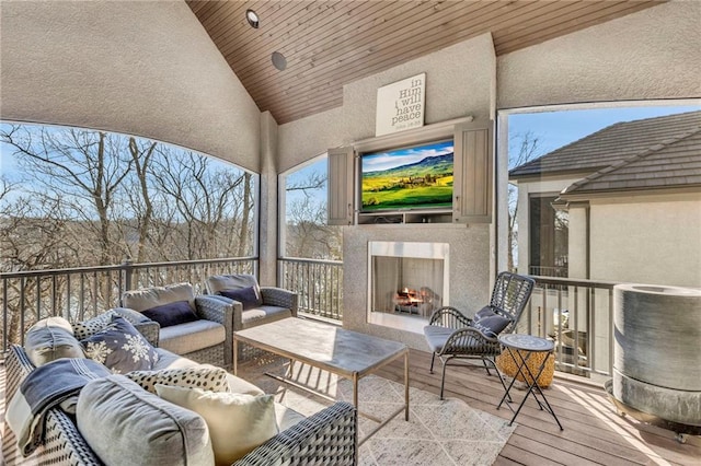 sunroom / solarium featuring wooden ceiling, an outdoor fireplace, and vaulted ceiling