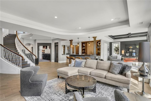 living room with indoor bar and a tray ceiling