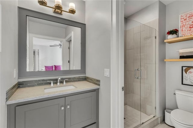 bathroom featuring ceiling fan, backsplash, a shower with door, and toilet