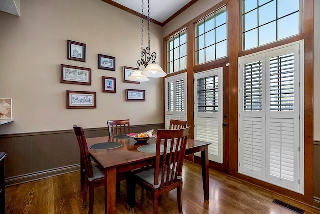 dining space featuring ornamental molding and dark hardwood / wood-style flooring