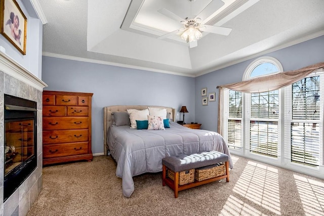 bedroom with ceiling fan, light colored carpet, crown molding, and a tray ceiling